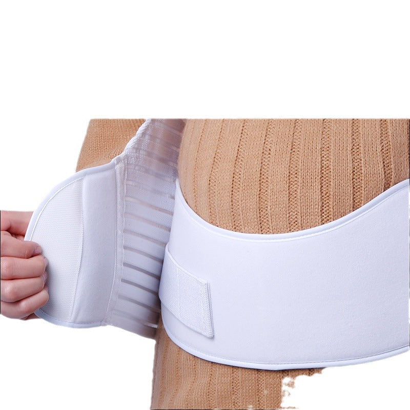 Skin tone maternity belly support belt worn over clothing from the front