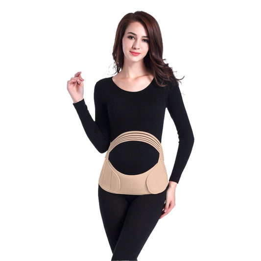 Model wearing a beige adjustable maternity belly support belt over black clothing