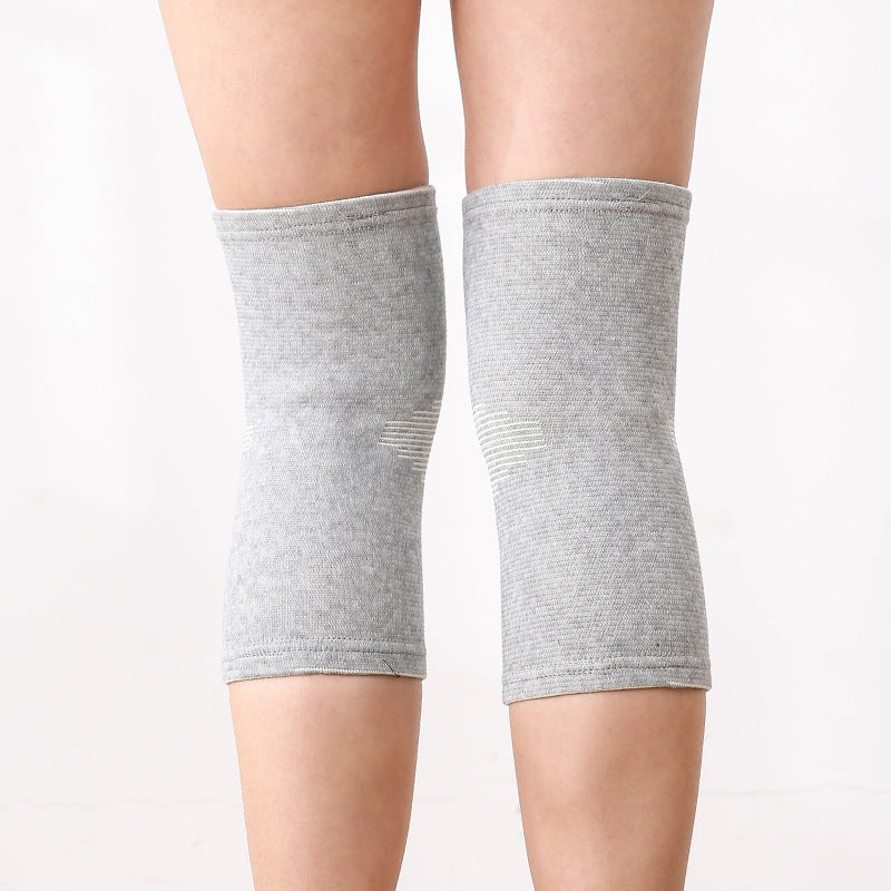Gray pair of knitted knee support sleeves worn on both knees front view