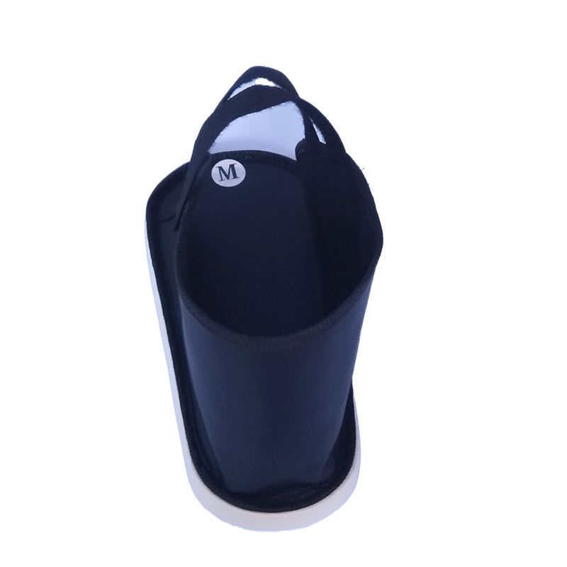 Side view of black open-toe recovery shoe cover with supportive sole