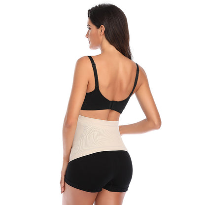 Pregnant model wearing a skin tone maternity belly support belt with wraparound abdominal support