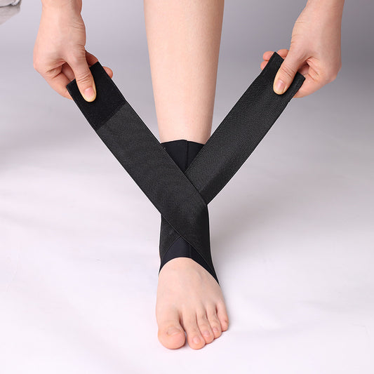 Black adjustable ankle brace worn on foot with heel opening and wrap straps