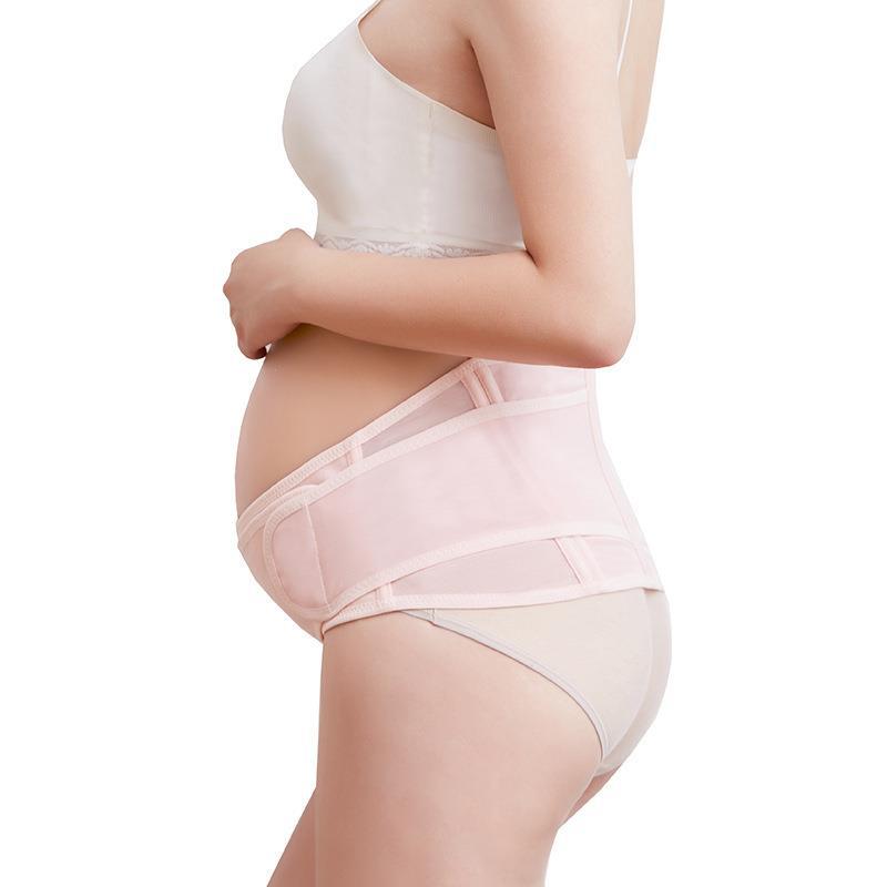 Pregnant model wearing pink adjustable maternity belly support belt, side view