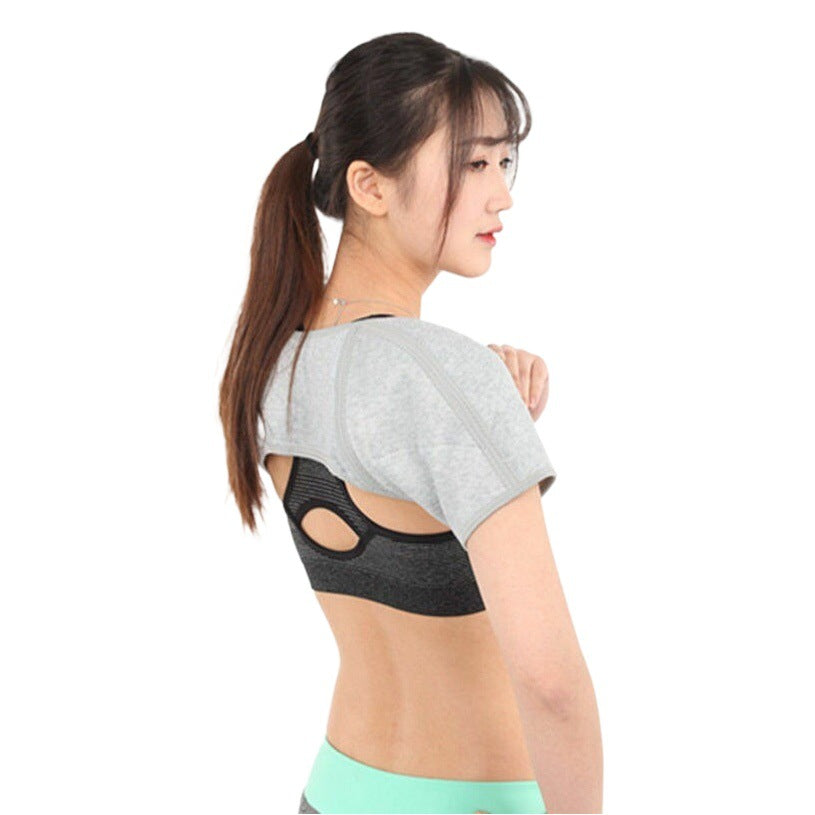 Adult model wearing adjustable shoulder support brace with upper back coverage on a white background
